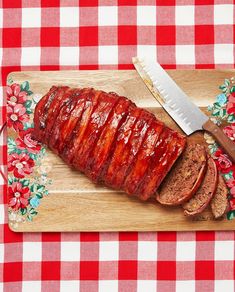 a large piece of meat on a cutting board with a knife