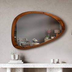 a mirror that is on the wall above a table with vases and candles in front of it