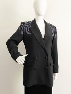 "This is a black wool double breasted blazer from Claude Bert, made in France.  The jacket has buttons and a hook and eye for closure.  Fully lined with shoulder pads.  The shoulders are embellished with black floral applique and beautiful sequins.  Great \"Dynasty\" piece.  European sizing 38.  Check measurements carefully, no stretch.  Measurements taken with jacket laying flat and doubled where appropriate. In order to determine fit we recommend comparing measurements with a jacket that fits you well.  Length 30 inches Underarm to underarm 38 inches Sleeve 22 inches Waist 32 inches Shoulder to shoulder 16 inches Always happy to answer questions. All sales considered final unless item is grossly misrepresented. Thank you for shopping with us at We Wear Vintage! 104" Breasted Blazer, Double Breasted Blazer, Floral Applique, Upcycle Clothes, We Wear, Black Wool, Shoulder Pads, Black Floral, Made In France