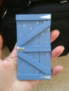 a hand holding a blue door with stars on it