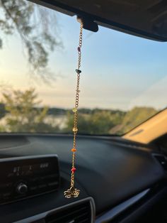 a car dashboard with a chain hanging from it's dash board and the sunroof