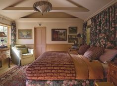 a large bed sitting in a bedroom next to a window with curtains on the windowsill