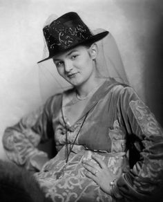 an old black and white photo of a woman wearing a hat