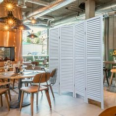 the interior of a restaurant with wooden tables and chairs in front of an open door