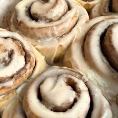 cinnamon rolls with icing sitting on top of each other