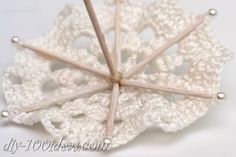 a crocheted doily with pins attached to it