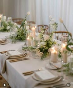 the table is set with white flowers and candles