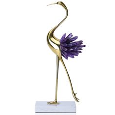 a gold statue with purple flowers on it's legs and arms, standing in front of a white background