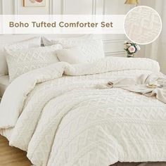 a bed with white comforter and pillows on it