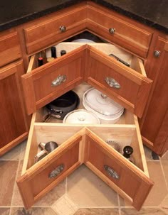 an open drawer in a kitchen with pots and pans