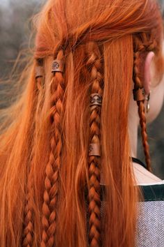 an orange haired woman with long braids on her head