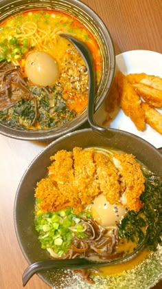 three metal pans filled with food on top of a wooden table