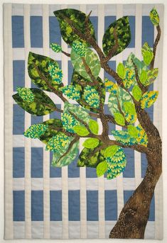 a painting of a tree with green leaves on blue and white checkered paper background