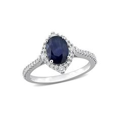 an oval shaped blue sapphire and diamond ring with shoulders set in 18k white gold