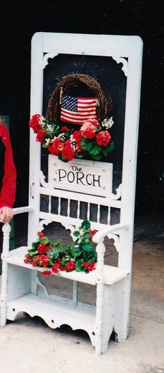 the porch sign is decorated with flowers and a wreath on it's back end