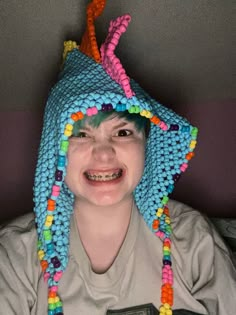 a young boy wearing a crocheted hat with beads on it's head