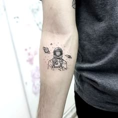 a man with a tattoo on his arm that has an astronaut in space and stars