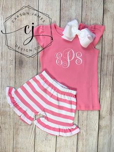 Check out this adorable monogram pink shirt and matching shorts! The perfect outfit for spring and summer!The shirt is an angel sleeve shirt in a beautiful bubble gum pink color. The pants are pink and white stripe with an elastic waist and ruffles around the bottom. We also have the outfit available in navy, peach, red, and navy! If interested in one of these colors please message us for availability!The shirt features a large monogram on the center of the chest that is embroidered directly ont Cute Short Pink Top, Playful Pink Ruffled Shorts, Cute Pink Ruffled Shorts, Short Pink Cotton Tops, Cute Pink Short Top, Cute Pink Cotton Short Set, Cute Pink Sets With Short Sleeves, Pink Cotton Sets With Short Sleeves, Cute Pink Short Sets