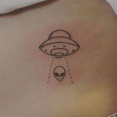 an alien tattoo on the back of a woman's stomach is shown in black and white