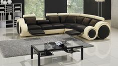 a modern living room with black and white furniture in the center, including a large sectional sofa