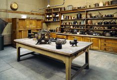 an old fashioned kitchen with lots of pots and pans on the table in front of it