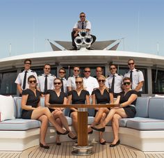 a group of people sitting on top of a boat next to each other in front of a table