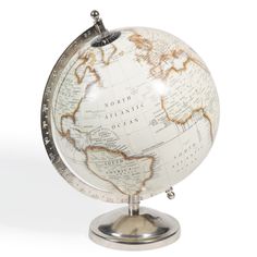 a white and gold globe on a metal stand