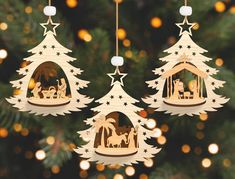 three wooden christmas ornaments hanging from a tree