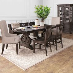 a dinning room table with chairs and a potted plant on top of it