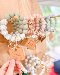 a person is holding several bracelets on display