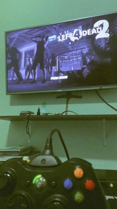 a video game controller sitting in front of a tv with the walking dead 2 on it