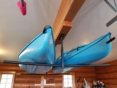 two blue canoes are hanging from the ceiling