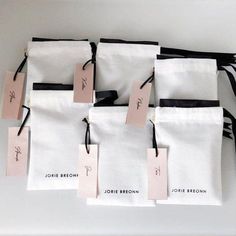 four bags with tags attached to them sitting on a table