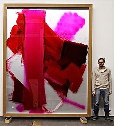 a man standing in front of a large painting