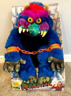 a blue monster stuffed animal sitting on top of a box