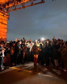 a woman standing in front of a crowd at night