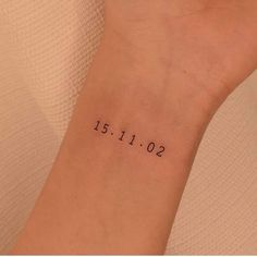 a woman's wrist with a date tattoo on the left side of her arm