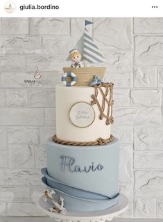 a blue and white cake with a boy on top