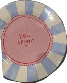 a blue and white plate with the words bon appetit written in red on it