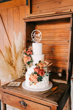 a white wedding cake sitting on top of a wooden table