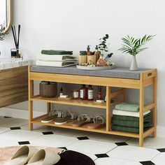 a wooden shelf with shoes and other items on it next to a sink in a bathroom