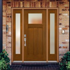 a wooden door with glass on the side of a brick building next to some plants