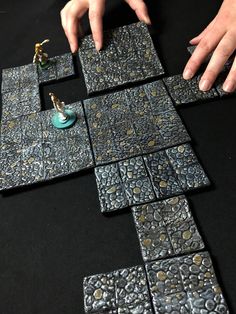 two hands are reaching for the tiles on the table