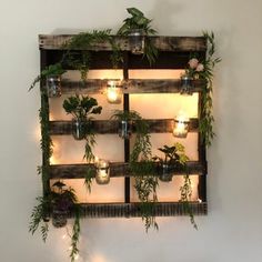 a wooden pallet filled with plants and lit candles