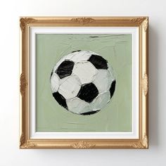 a painting of a black and white soccer ball on a green background in a gold frame