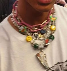 a close up of a person wearing a necklace with beads and other items on it