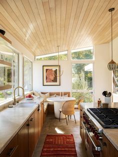 a kitchen with wooden ceiling and white counter tops