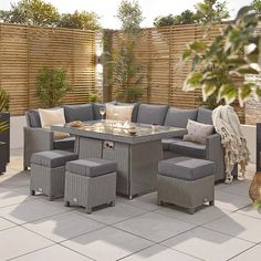 an outdoor patio with grey wicker furniture