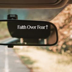 a rear view mirror with the words faith over fear written on it