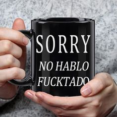 a person holding a black coffee mug with the words sorry no hablo fuktao